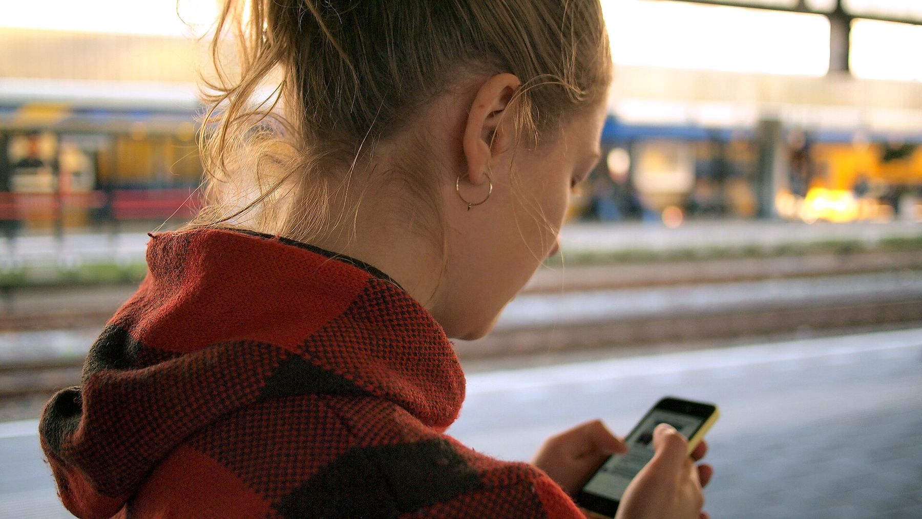 A woman checking her phone on the street